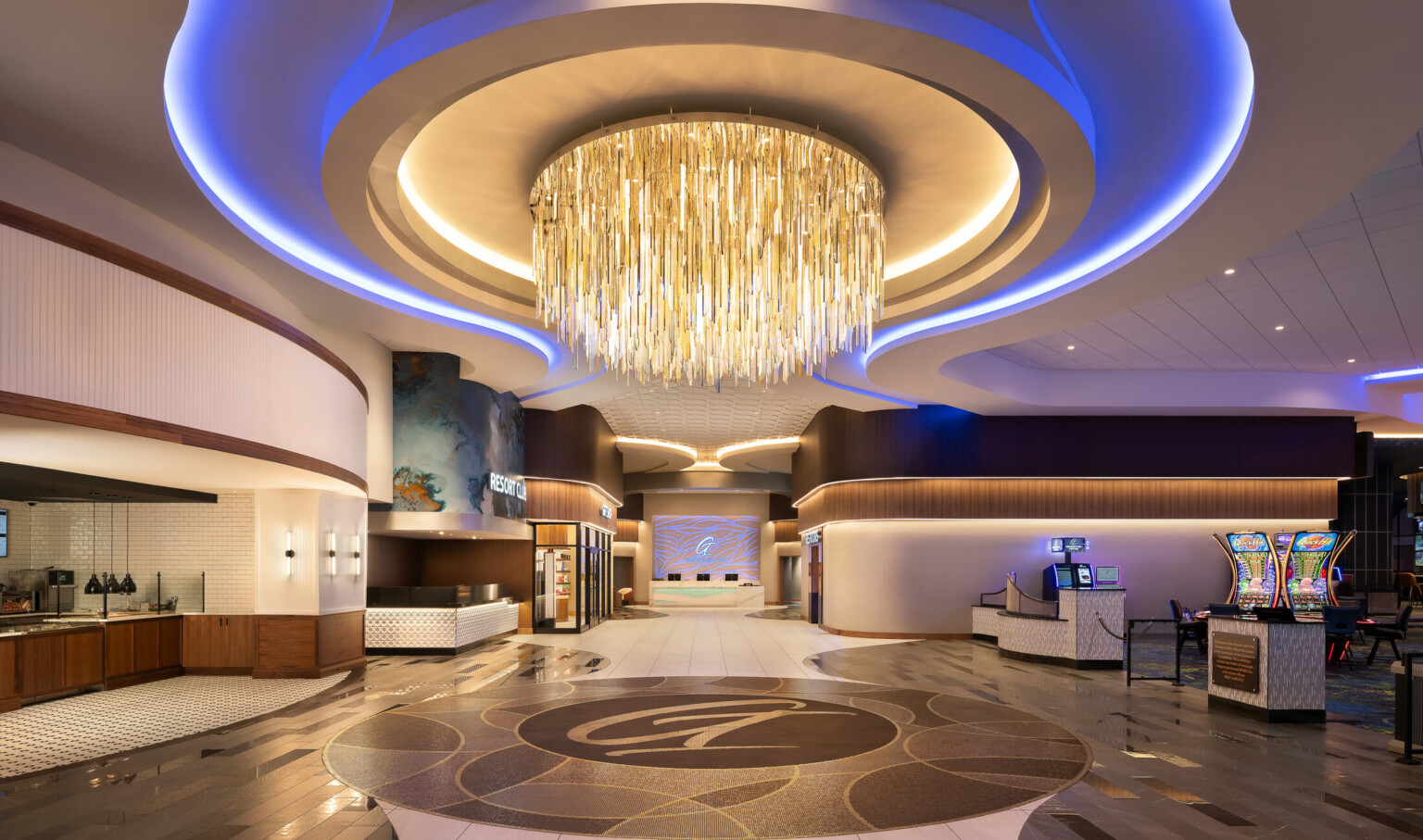 Casino resort lobby with cascading glass chandelier, mirrored check-in desk, and quartz wall etched with river patterns; Grand Island Casino Resort at Fonner Park