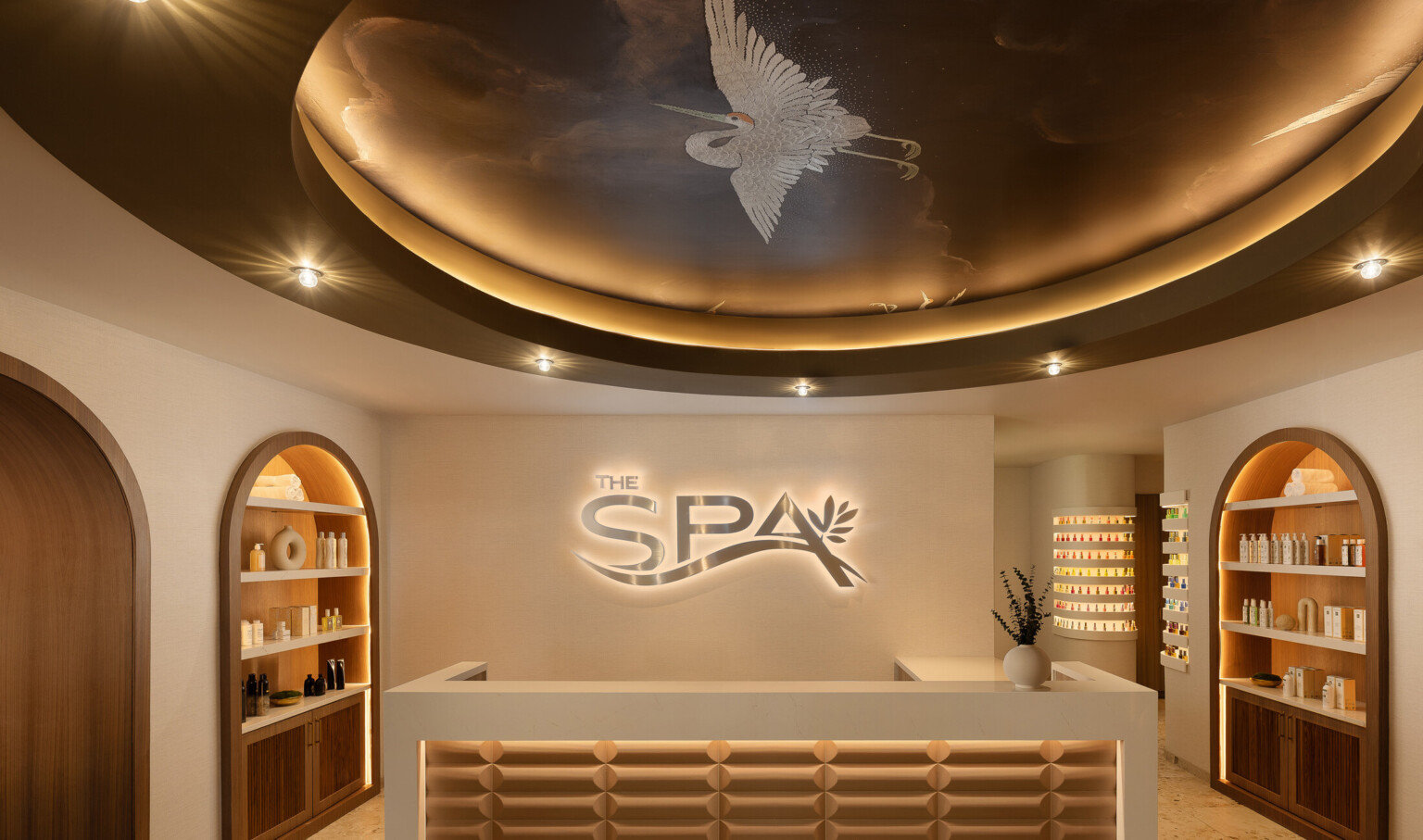 Grand Island Casino Resort at Fonner Park Spa entrance and reception desk with neutral, calming tones; circular lighting above front desk with spa logo on the back wall