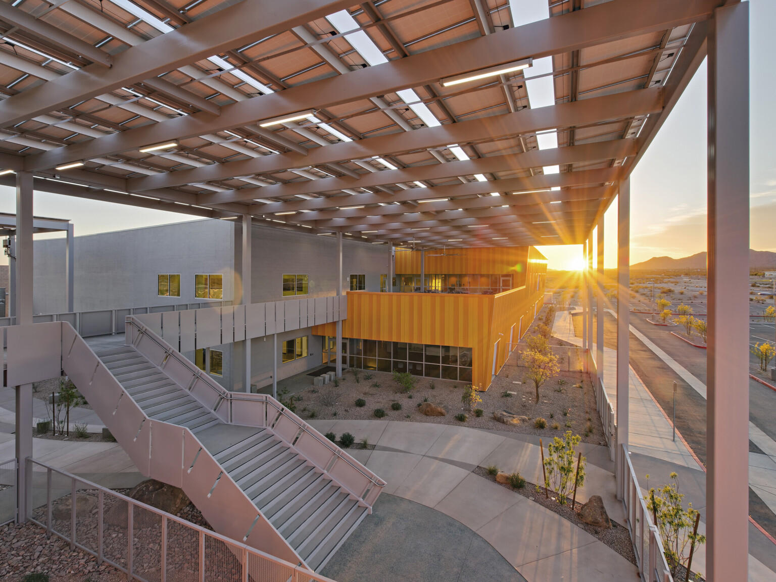 Western Maricopa Education Center (West-MEC) Southwest campus entrance. A 2 story grey and yellow building with solar canopy