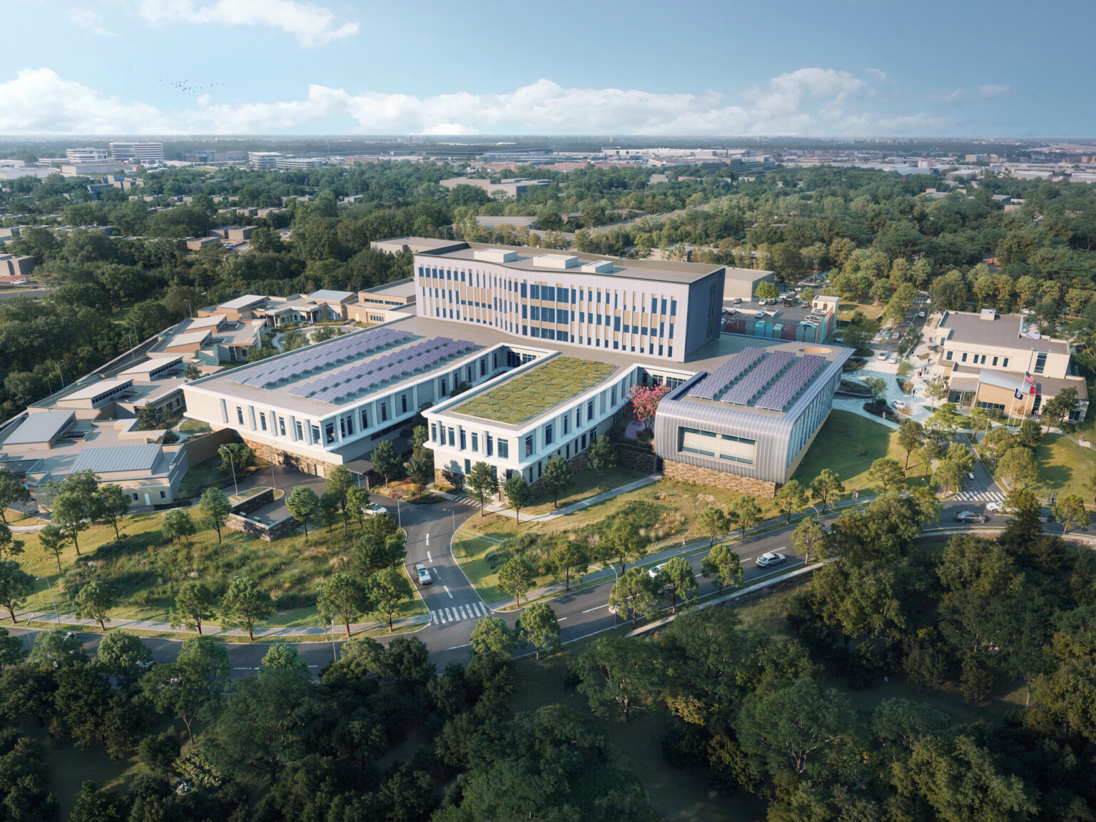 Long building on green lawn with large windows and white wrap facade