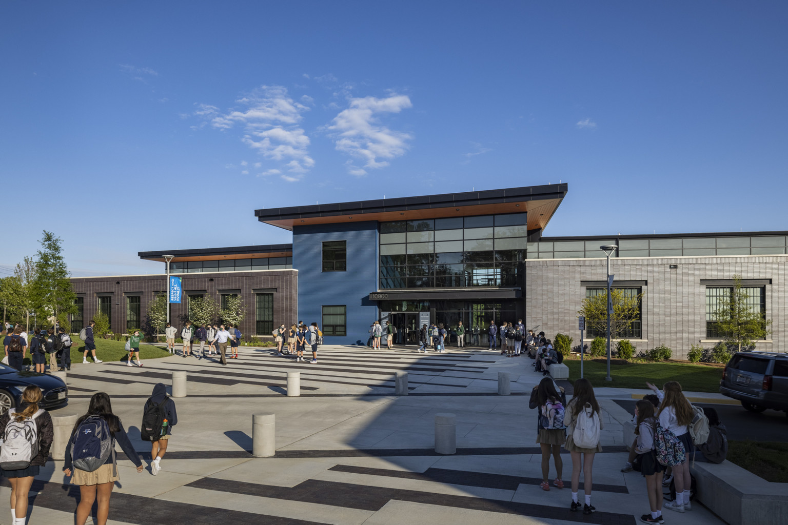 students walking up to peterson middle school with a double-height glass atrium flanked by a modern brick façade