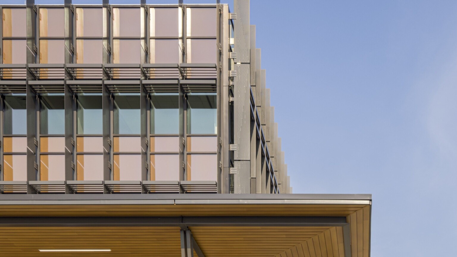 close up shot of a modern building exterior; architectural vertical design elements along the windows