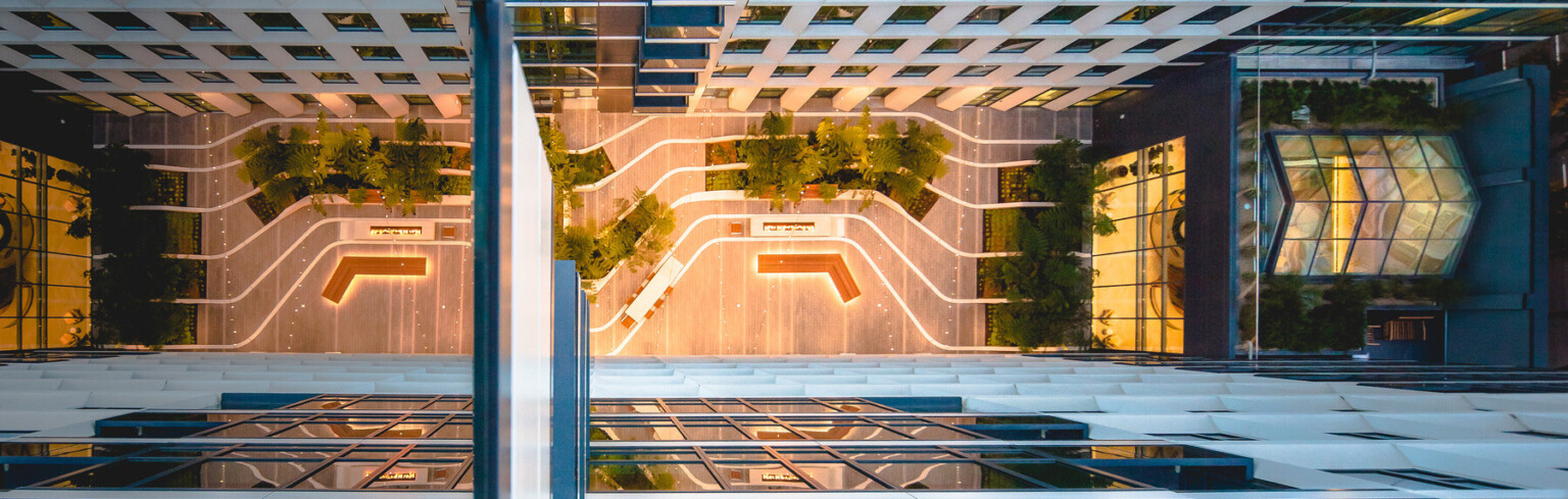night time aerial view into an urban courtyard between two glass hig hrise buildings; dlr group design