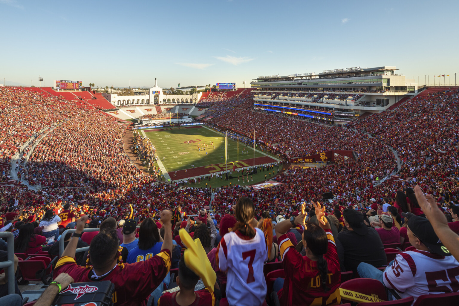 Full stadium of fans in red during dusk football game at the LA Memorial Coliseum