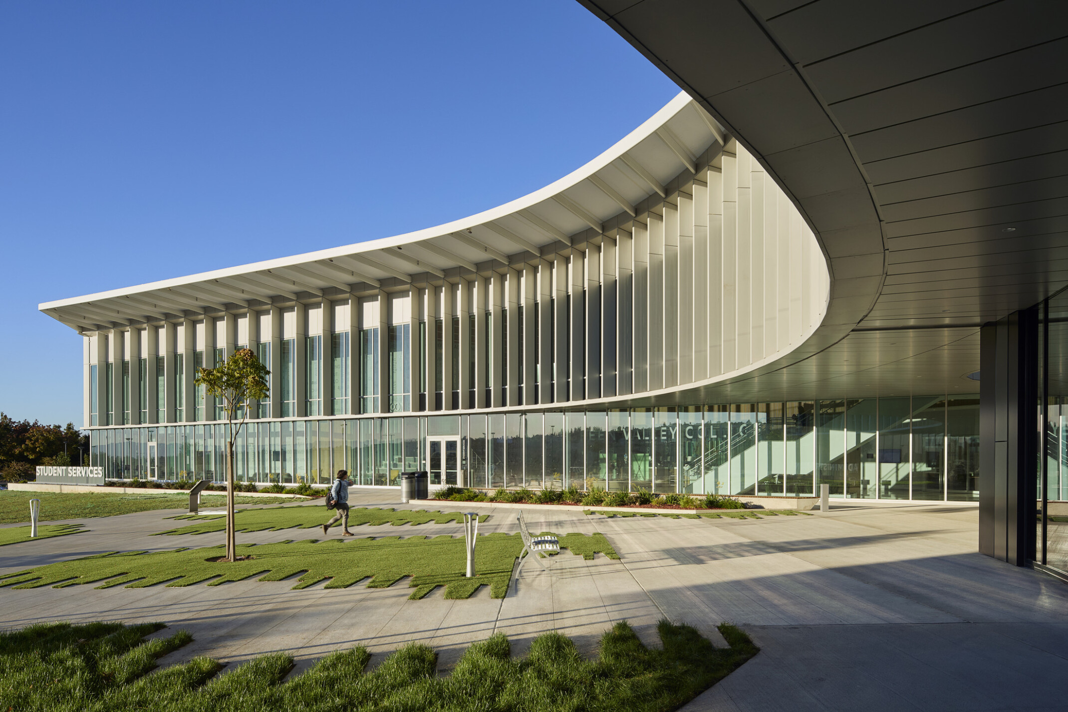 Multistory modern building with large glass panels and a curved roof